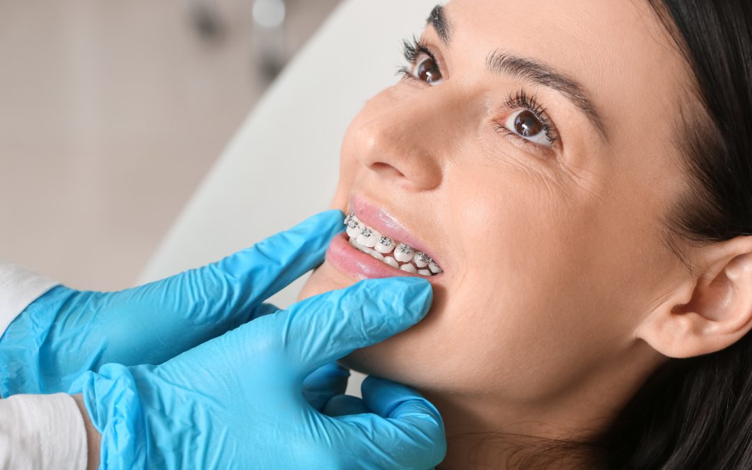 woman with braces smiling while visiting the dentist