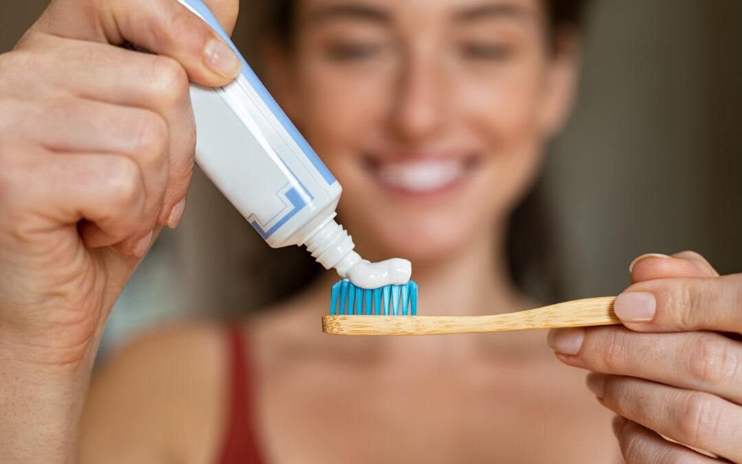 woman applying toothpaste to toothbrush